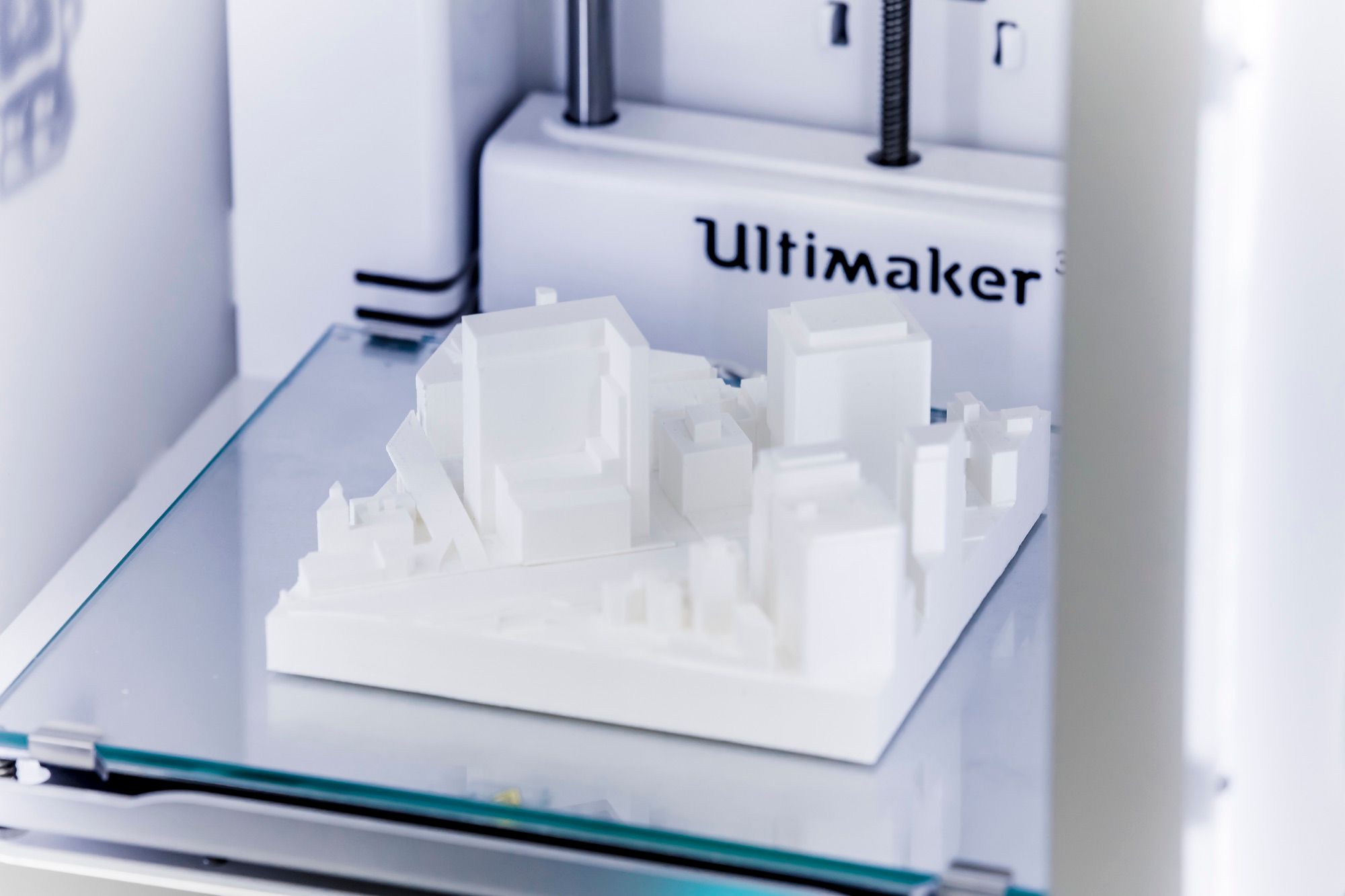White 3D-printed urban massing model on the build plate of a 3D printer