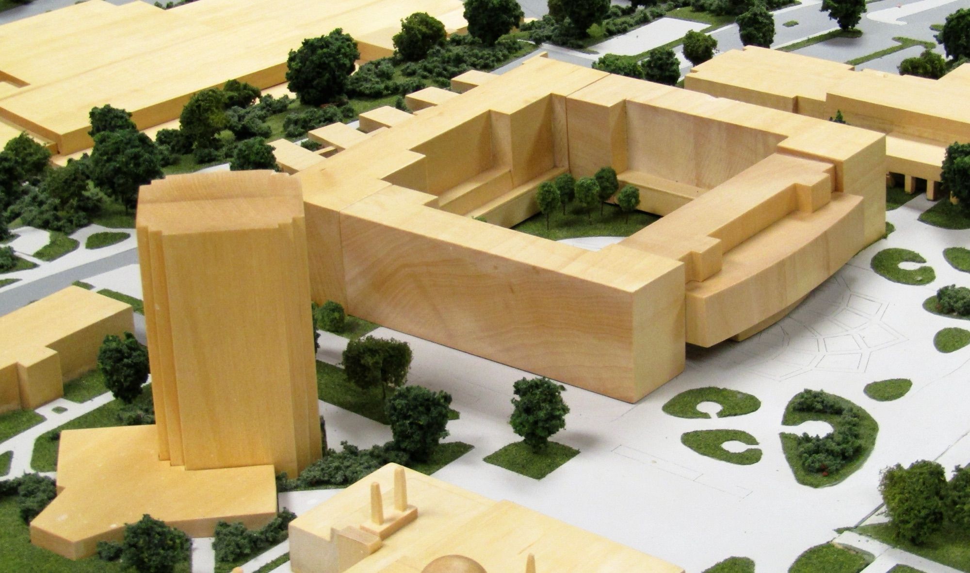 Maqueta de madera de edificios de un campus con árboles y zonas verdes a escala